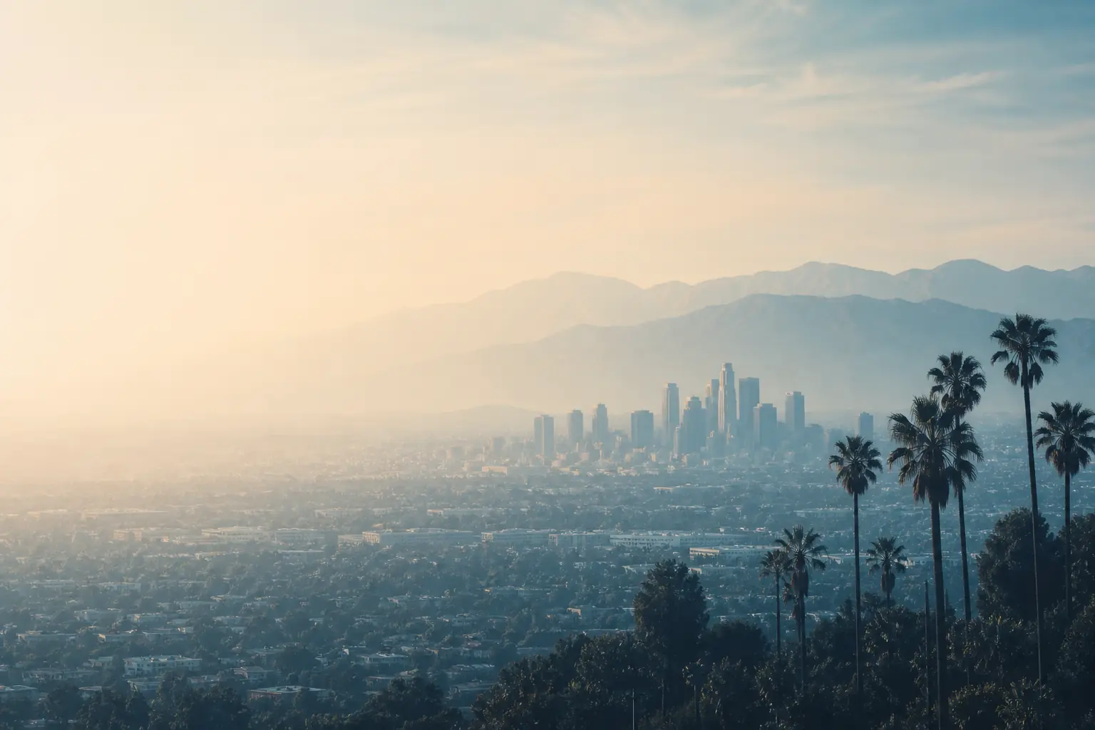 The downtown Los Angeles skyline with the San Gabriel Mountains behind it in coastal haze